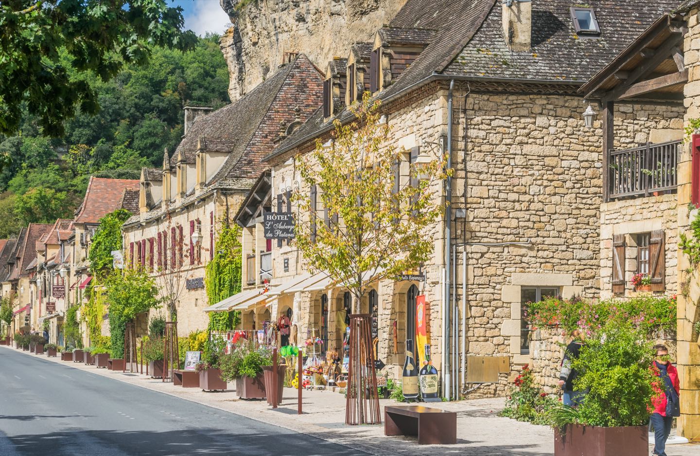 La Roque-Gageac village beside the Dordogne River below limestone cliffs.